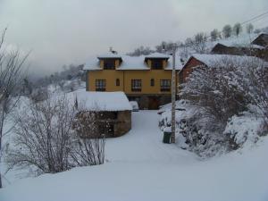 une maison recouverte de neige devant dans l'établissement El Quesar de Gamoneo, à Gamonedo de Cangas