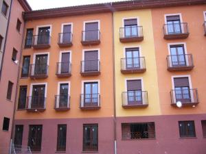 Un edificio alto con balcones a los lados. en Apartamentos Puerta Muralla, en Teruel