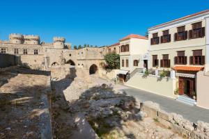 un ancien bâtiment avec un château en arrière-plan dans l'établissement Nikos Takis Fashion Boutique Hotel, à Rhodes