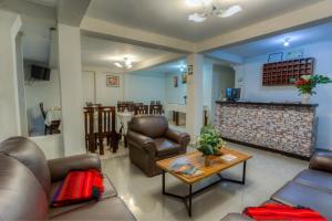 sala de estar con sillas de cuero y mesa de centro en Machupicchu Guest House, en Machu Picchu