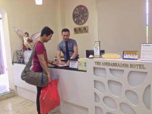 due persone in piedi al bancone in un negozio di The Ambassador Hotel a Tacloban