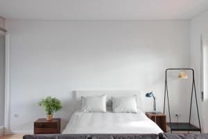 a white bedroom with a bed and a couch at São Miguel 50 in Porto
