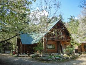 a log cabin in the woods with trees at Canadian Loghouse Inn AzuminoYujin in Azumino