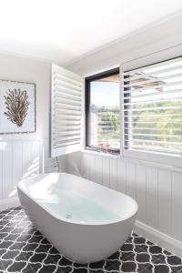 a white bath tub in a bathroom with a window at Bendooley Estate in Berrima