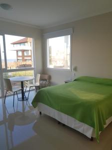Un dormitorio con una cama verde y una mesa en MitreCity en Ostende