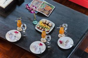 a table with plates of food and drinks on it at Villa Casis by Nagisa Bali in Sanur