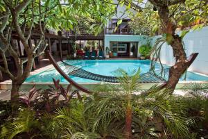 a swimming pool with a hammock in a resort at Villa Casis by Nagisa Bali in Sanur