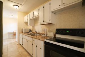 a kitchen with white cabinets and a black stove top oven at House 3 blocks to the beach in Panama City Beach