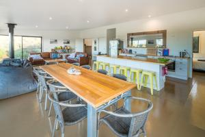 cocina y sala de estar con mesa de madera y sillas en Sawyers Bay Shacks, en Emita