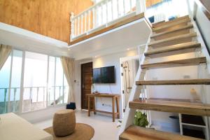 a living room with a staircase and a tv at Changmoi House (Little Village) in Chiang Mai