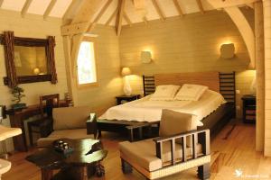 1 dormitorio con 1 cama y sillas en una habitación en Cabane d'Amour, en Béziers