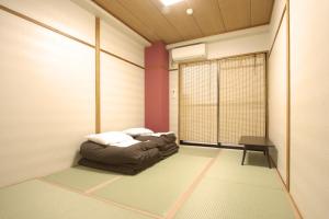 a room with a bed in the corner of a room at Toyotaya Hostel in Nishinomiya