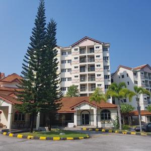 a large apartment building with a tree in front of it at Twin Luck Home Stay in Ipoh