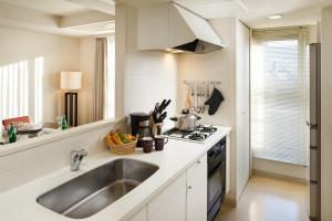 a kitchen with a sink and a stove at Oakwood Residence Aoyama in Tokyo