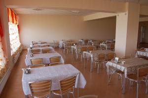a room full of tables and chairs with white linens at Sanatoriy Zhosaly in Qarqaraly
