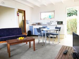 a living room with a table and chairs and a kitchen at Martinborough Motel in Martinborough 