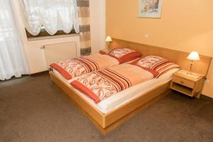 a bedroom with a large bed with two pillows at Apartmenthaus Weber in Arrach