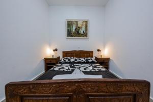 - une chambre avec un lit en bois et 2 tables de chevet dans l'établissement Apartman Lavanda, à Kaštela