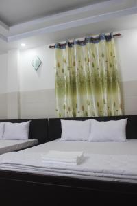 HaiVan HosTel في تشاو دوك: سرير في غرفة مع نافذة مع ستارة