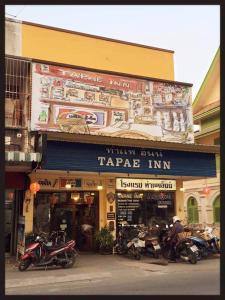 a group of motorcycles parked in front of a store at Tapae Inn Hotel in Chiang Mai