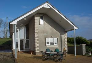 a small house with a patio and a table at The Doc's self catering in Greencastle