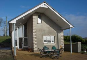 uma pequena casa com um pátio e uma mesa em The Doc's self catering em Greencastle