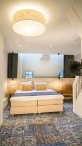 Dormitorio con cama y lámpara de araña grande en Hotel Nes, en Ámsterdam