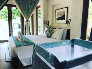 a bedroom with a large bed and a tub at Villa Samudera in Nusa Lembongan