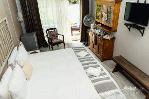 a bedroom with a white bed and a television at Mirabel Guesthouse in Parys
