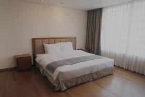 a bedroom with a large bed and a large window at Vabien Suite 1 Serviced Residence in Seoul