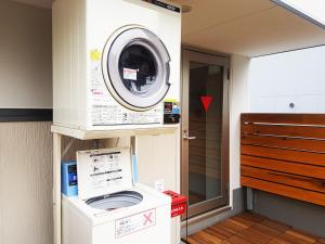a washer and dryer in a small room at Poly Hostel 2 Namba in Osaka