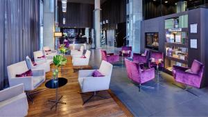 a lobby with white chairs and purple chairs at Sercotel Boulevard Vitoria-Gasteiz in Vitoria-Gasteiz