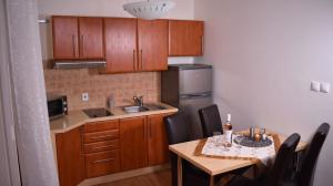 a small kitchen with a table and a sink and a refrigerator at Beška in Bešeňová