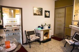 a living room with a fireplace and a table and chairs at Hotel Garni Trumm in Dillingen an der Donau