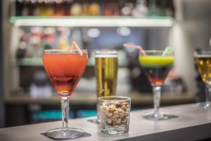 three glasses of drinks on a bar with snacks at Hotel Victoria Lyon Perrache Confluence in Lyon