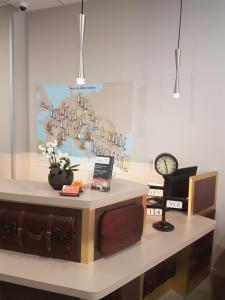 a room with a desk with a clock on it at Hotel Victoria Lyon Perrache Confluence in Lyon