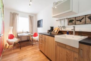 eine Küche mit einem Waschbecken und einem Schreibtisch in einem Zimmer in der Unterkunft Wohnen an der Juliuspromenade Stadt in Würzburg