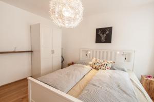 Schlafzimmer mit einem Bett mit Kronleuchter in der Unterkunft Wohnen an der Juliuspromenade Stadt in Würzburg