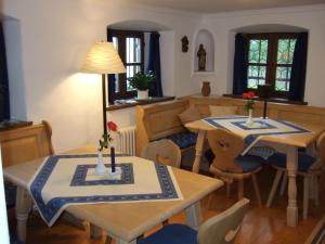 a dining room with two tables and chairs at Gästehaus Banik in Seebruck