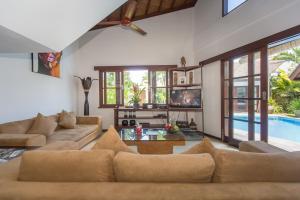 a living room with a couch and a pool at Villa Origami by Nagisa Bali in Seminyak
