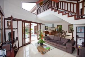 a living room with a couch and a staircase at Villa Origami by Nagisa Bali in Seminyak