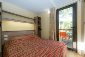 a bedroom with a bed and a sliding glass door at VTF Les Oyats Sylvadoures in Maubuisson +37 photos