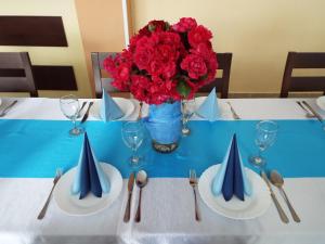 una mesa con platos y un jarrón de flores. en Penzión Lindava, en Budmerice