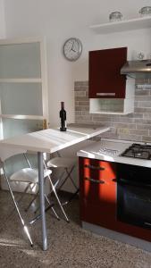 uma cozinha com uma mesa, um fogão e um relógio em In Vacanza da Marinella em Albenga