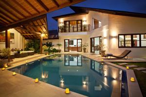 a swimming pool in front of a house at night at Villa Origami by Nagisa Bali in Seminyak