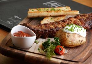a plate of food with meat and bread and sauce at Hotel Sachsenklemme in Fortezza