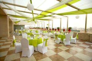 a banquet hall with tables and chairs and windows at Park Ascent in Noida