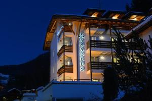 un edificio con un cartello sopra la notte di Alpin-Residence Amadeus a Siusi