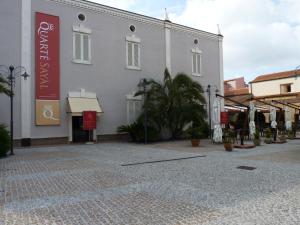 アルゲーロにあるQuarté Sayàlの通りの赤い看板白い建物