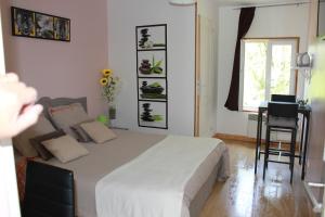 1 dormitorio con cama, mesa y ventana en Le Moulin Traffay, en Saint-Didier-sur-Chalaronne